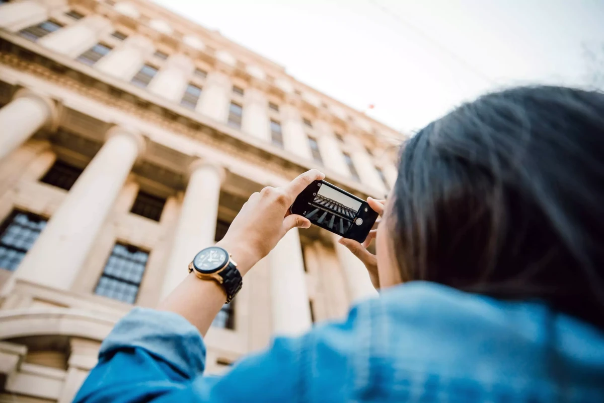 Bir binanın fotoğrafını çeken turist